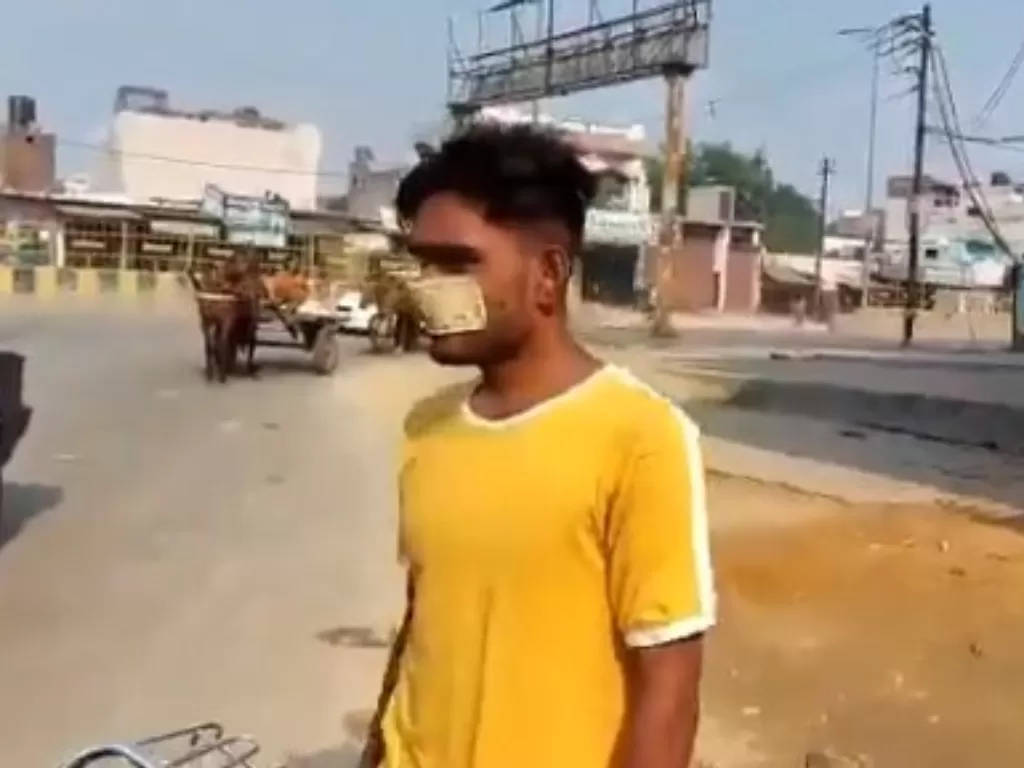 Pria India gunakan uang 10 rupee sebagai masker. (Screenshot)