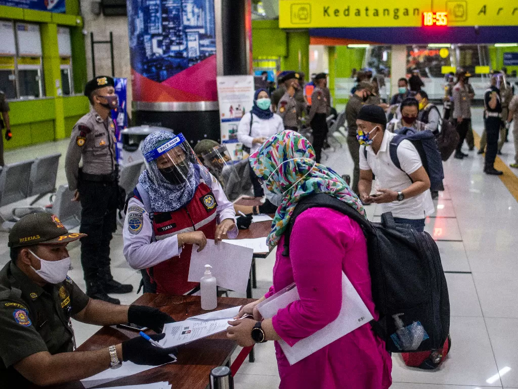 Petugas melakukan pemeriksaan dokumen Surat Izin Keluar-Masuk (SIKM) sebagai syarat mutlak yang harus dimiliki oleh warga untuk keluar atau masuk ke wilayah Jakarta di Stasiun Gambir. (ANTARA/Aprillio Akbar)
