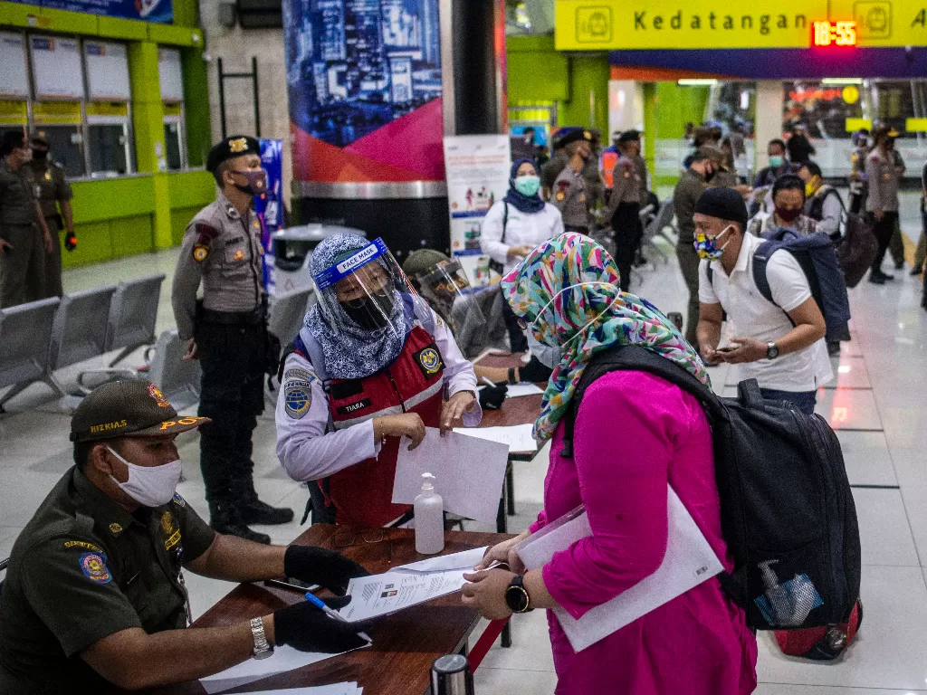 Petugas melakukan pemeriksaan dokumen penumpang Kereta Api Luar Biasa (KLB) Gambir-Surabaya Pasarturi saat tiba di Stasiun Gambir, Jakarta. (ANTARA FOTO/Aprillio Akbar)