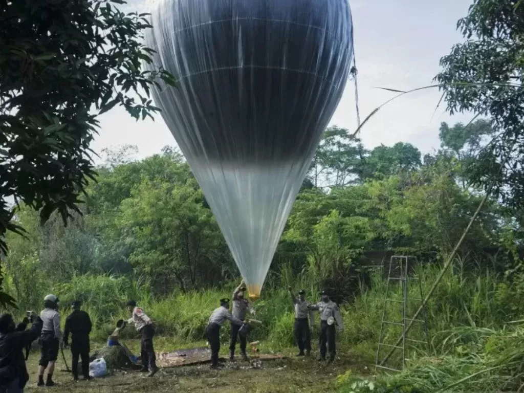 Polisi menyita balon udara yang akan diterbangkan oleh warga di Pekalongan, Jawa Tengah, Minggu (31/5/2020). (ANTARA/Harviyan Perdana Putra)
