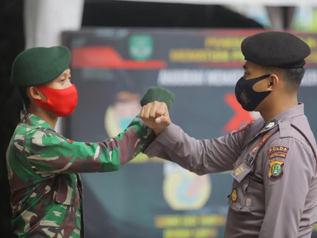 Ilustrasi anggota TNI dan Polri mengawal kedisiplinan warga dalam menjalankan protokol kesehatan, menyusul rencana penerapan New Normal. (ANTARA/Reno Esnir)