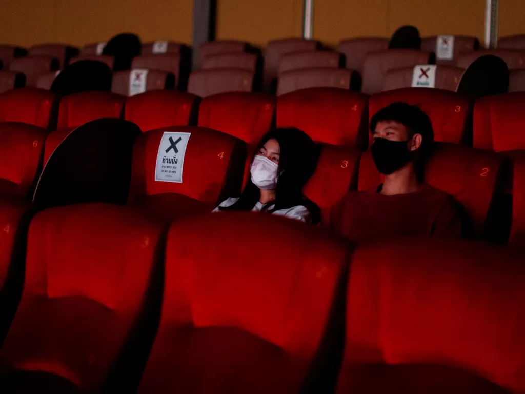 Penonton memakai masker saat menonton film di bioskob di Bangkok, Thailand, Senin (1/6). (photo/REUTERS/Jorge Silva)