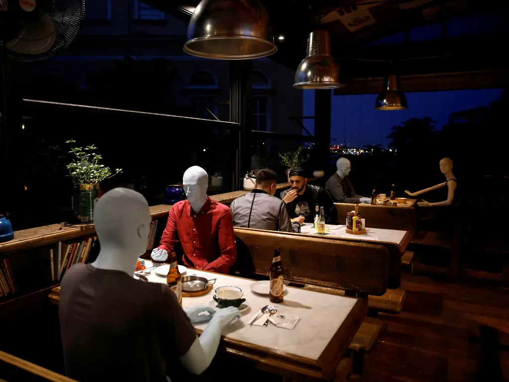  Sejumlah manekin terlihat ditempatkan di antara meja sebagai pembatas bagi pelanggan sesuai dengan aturan jarak sosial di kafe yang dibuka kembali, di Istanbul, Turki (1/6/2020). (REUTERS/Umit Bektas)