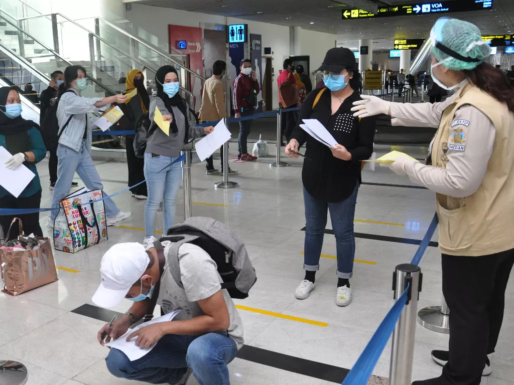 Petugas karantina meminta dokumen kesehatan para pemudik Warga Negara Indonesia (WNI) saat tiba di terminal kedatangan internasional Bandara Kualanamu Kabupaten Deliserdang, Sumatera Utara. (ANTARA FOTO/Septianda Perdana)