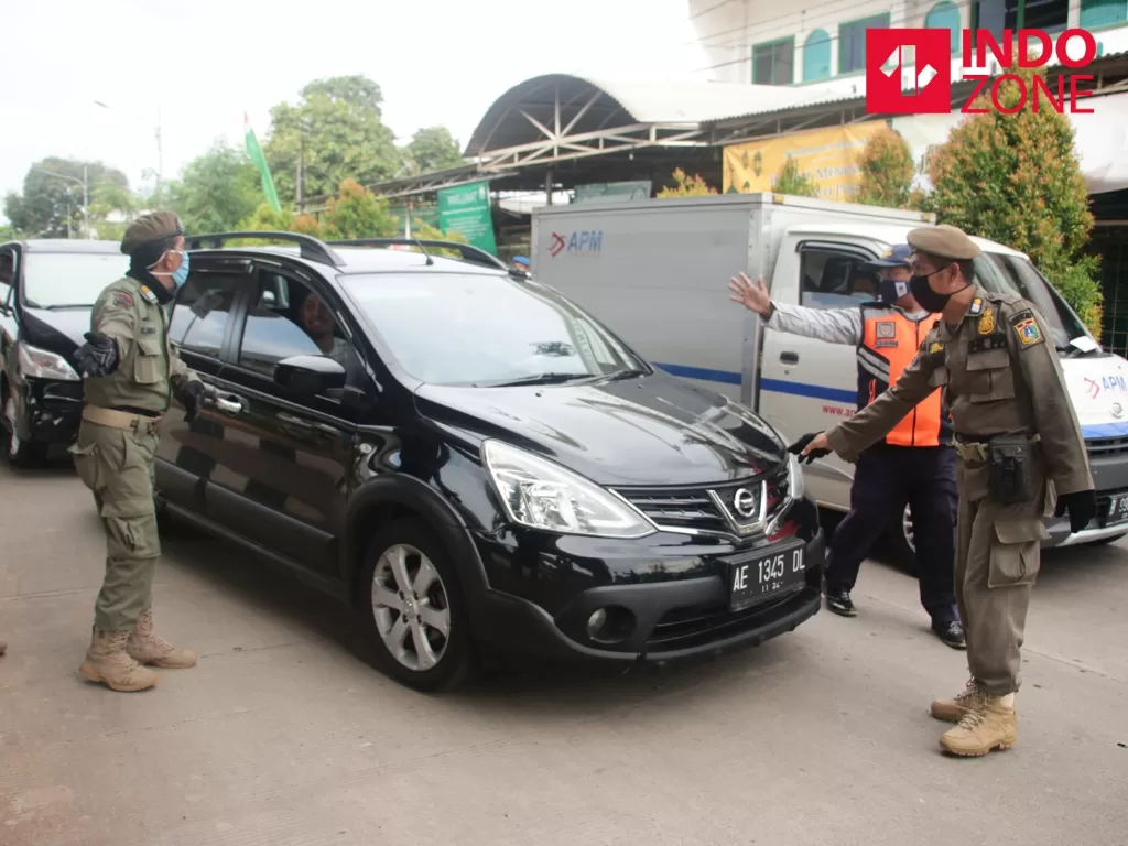  Petugas memeriksa kelengkapan Surat Izin Keluar Masuk (SIKM) Jakarta di Cek Poin PSBB Lampiri, Kalimalang, Jakarta, Selasa (26/5/2020). (INDOZONE/Febio Hernanto) 