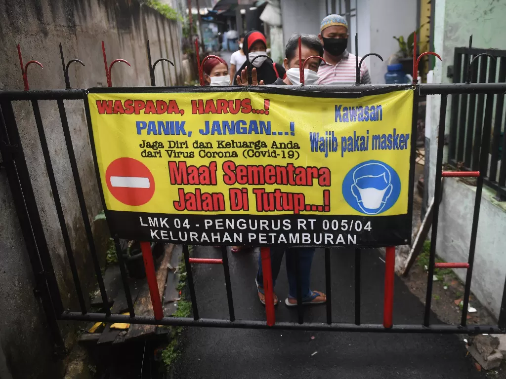 Warga menutup jalan saat simulasi pelaksanaan Pembatasan Sosial Berskala Lokal (PSBL) di RT 05 RW 04, Petamburan, yang merupakan wilayah zona merah corona di Jakarta, Rabu (3/6/2020). (ANTARA FOTO/Akbar Nugroho Gumay)
