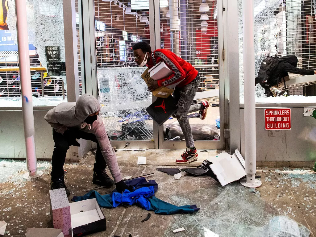 Para pengunjuk rasa menjarah sebuah toko setelah aksi protes kematian George Floyd, di wilayah Manhattan di New York City, AS, 1 Juni 2020. (REUTERS/Eduardo Munoz)