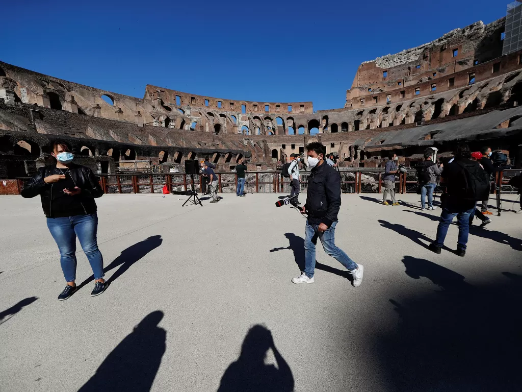 Sejumlah jurnalis mengenakan masker di Colosseum, Roma, Italia 1 Juni 2020. (REUTERS/Yara Nardi)
