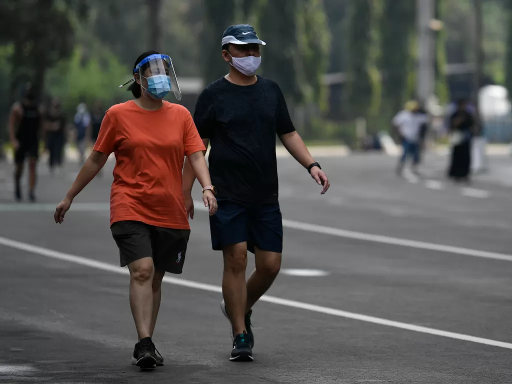  Warga mengenakan face shield saat berolahraga di Kompleks Stadion Utama Gelora Bung Karno (SUGBK), Jakarta, Sabtu (6/6/2020). (ANTARA FOTO/Puspa Perwitasari)