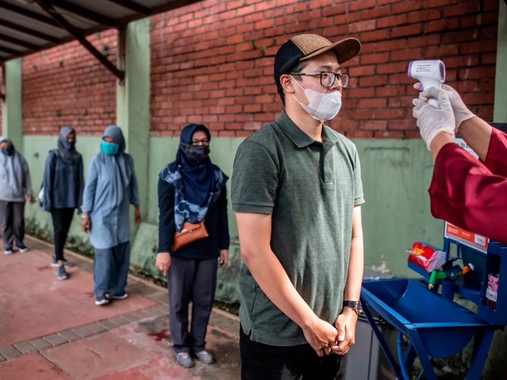 Wisatawan melakukan pengukuran suhu tubuh saat berlangsungnya simulasi normal baru di TMII, Jakarta, Kamis (4/5/2020). (Photo/ANTARA FOTO/Aprillio Akbar)