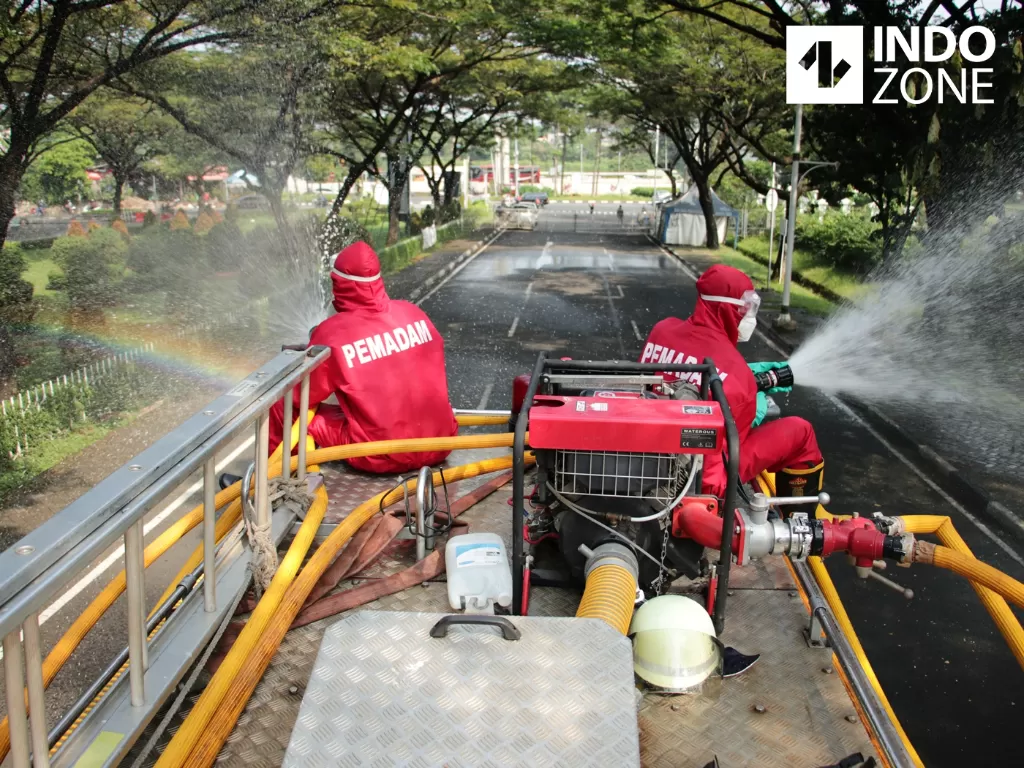 Petugas damkar melakukan penyemprotan cairan disinfektan di lokasi wisata Taman Mini Indonesia Indah (TMII), Jakarta Timur, Rabu (10/6/2020). (INDOZONE/Febio Hernanto)