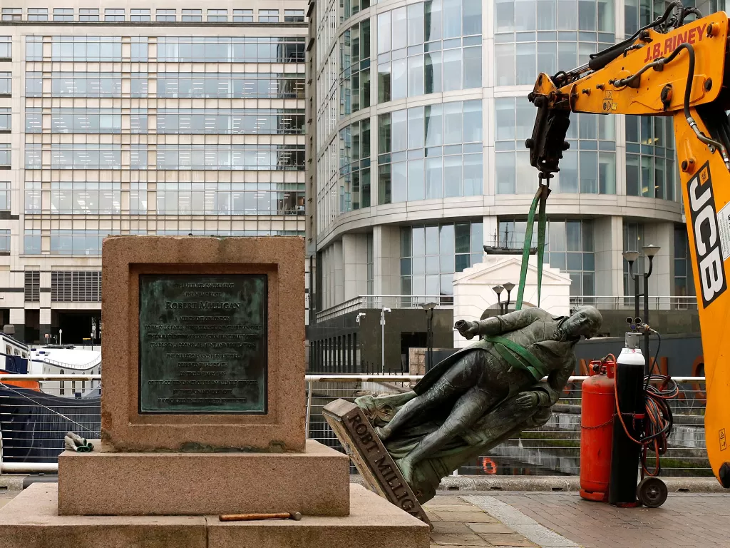 Patung Robert Milligan diturunkan oleh pekerja di luar Museum London Docklands, setelah kematian George Floyd yang meninggal dalam tahanan polisi, di London, Inggris, 9 Juni 2020. (REUTERS/John Sibley)
