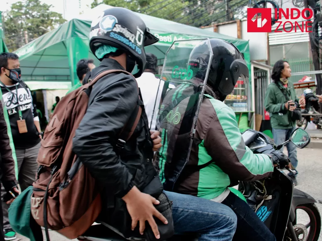 Pengemudi ojek online mengenakan sekat pelindung saat menunggu penumpang di kawasan Jalan Kendal, Jakarta, Kamis (11/6/2020). (Photo/INDOZONE/Febio Hernanto) 