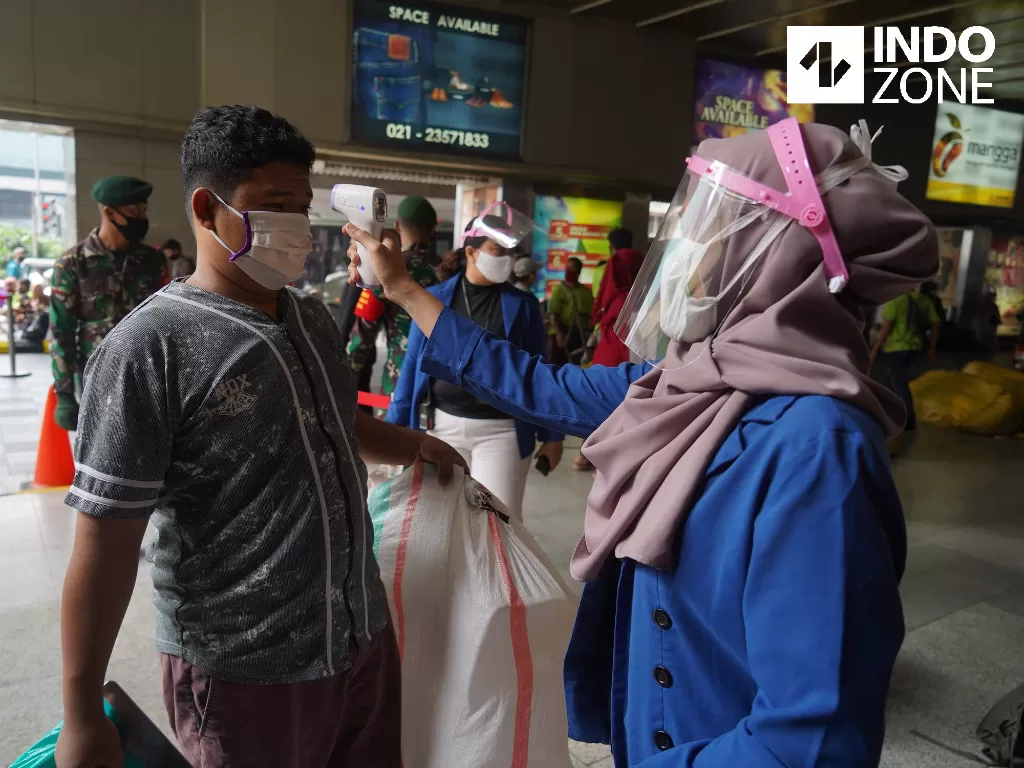 Pedagang melakukan pemeriksaan suhu tubuh di pintu masuk Pasar Tanah Abang Blok A, Jakarta, Senin (15/6/2020). (INDOZONE/Arya Manggala)