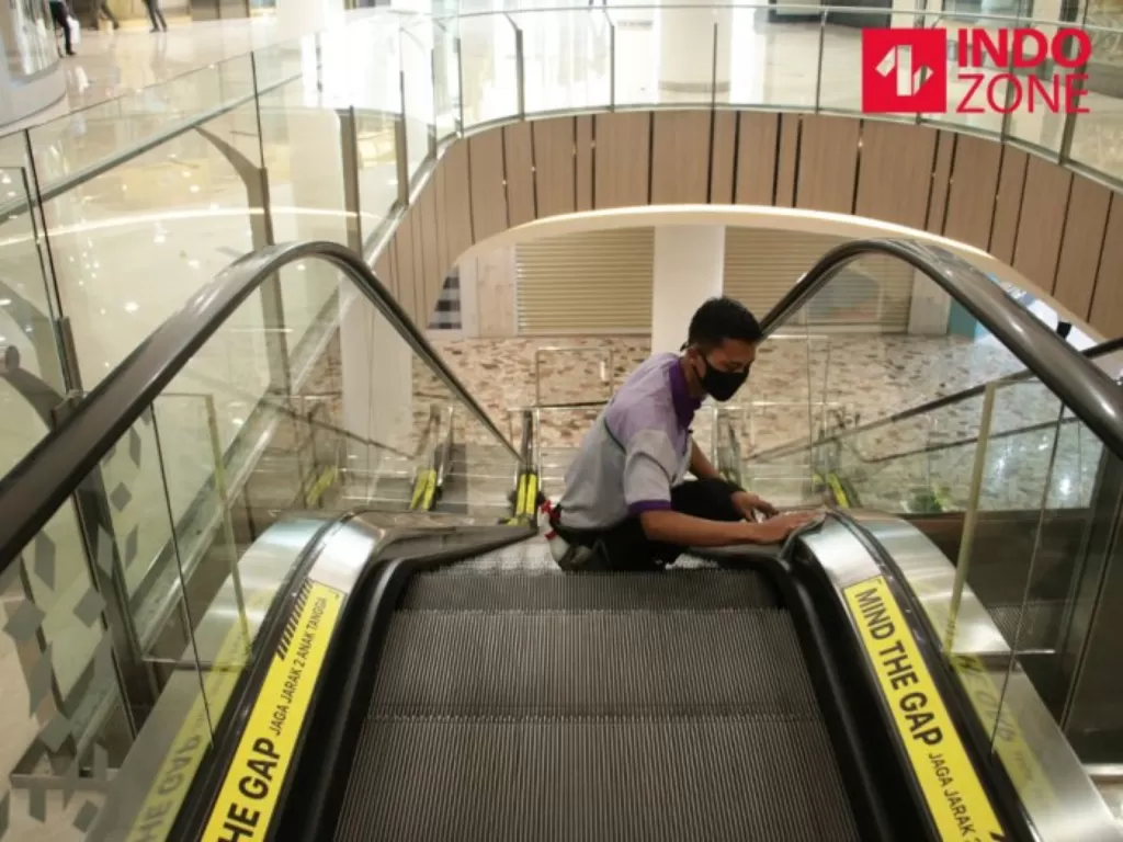 Ilustrasi petugas membersihkan tangga berjalan di mall. (INDOZONE/Febio Hernanto)
