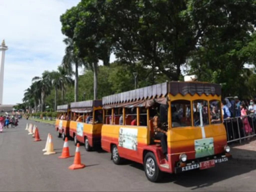 Pengunjung mengantre untuk menaiki mobil keliling di Monas, Jakarta, Selasa (27/6). Pada H+1 Idulfitri kawasan wisata monas masih ramai pengunjung. (Photo/ANTARA FOTO/Akbar Nugroho Gumay)
