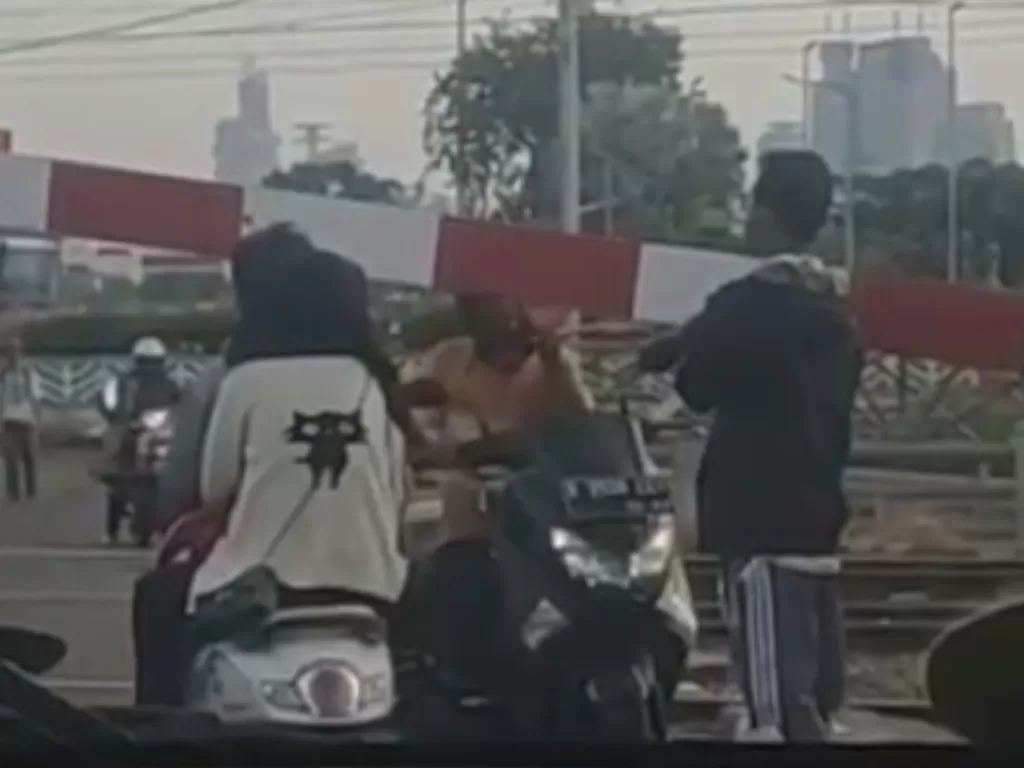 Tampilan pengendara motor yang paksa menerobos palang kereta api. (SS/Instagram/@agoez_bandz4)