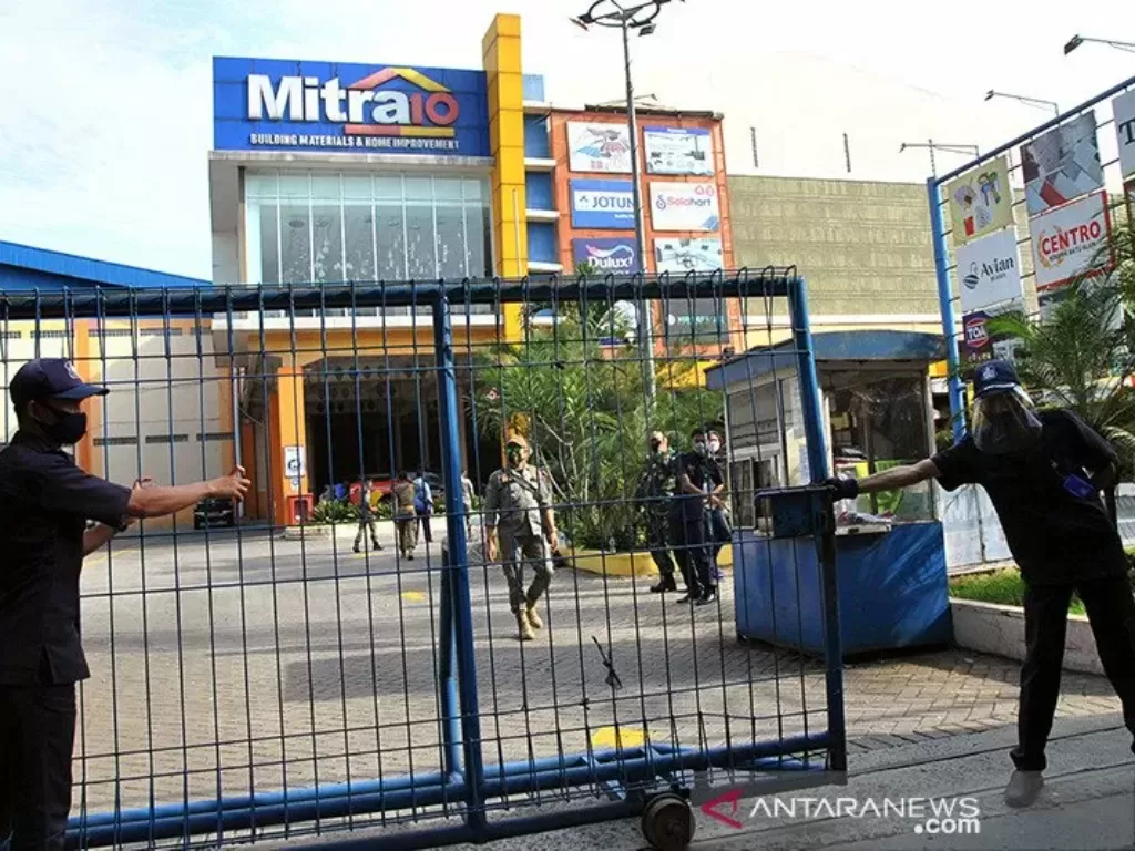 Petugas keamanan menutup pintu gerbang masuk saat penutupan supermarket Mitra10, Kota Bogor, Jawa Barat, Rabu (17/6/2020). (photo/ANTARA FOTO/Arif Firmansyah)