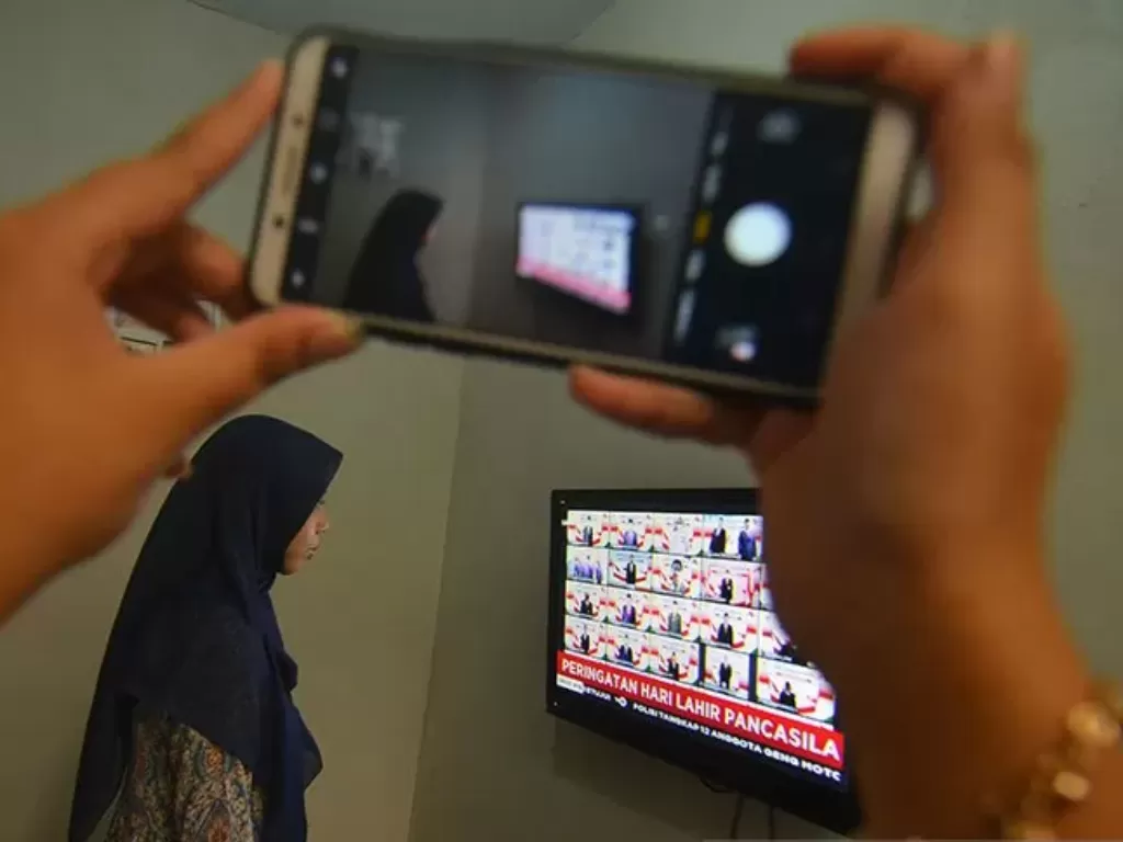 Seorang ASN mengikuti upacara peringatan Hari Lahir Pancasila melalui siaran langsung dari televisi di rumahnya di Imbanagara, Kabupaten Ciamis, Jawa Barat, Senin (1/6/2020). (photo/ANTARA FOTO/Adeng Bustomi)