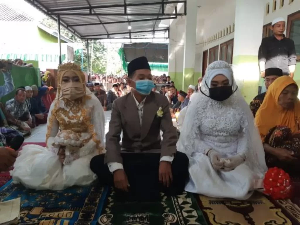 Saiful duduk bersanding dengan dua istri yang dinikahinya sekaligus, Hariani dan Mustiawati. (Foto: Istimewa)
