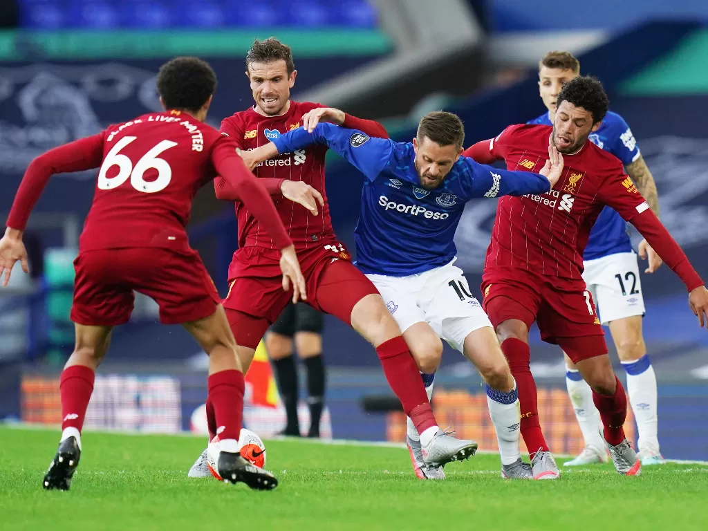 Tiga pemain Liverpool mencoba menghentikan pemain Everton. (Jon Super/Pool via REUTERS)