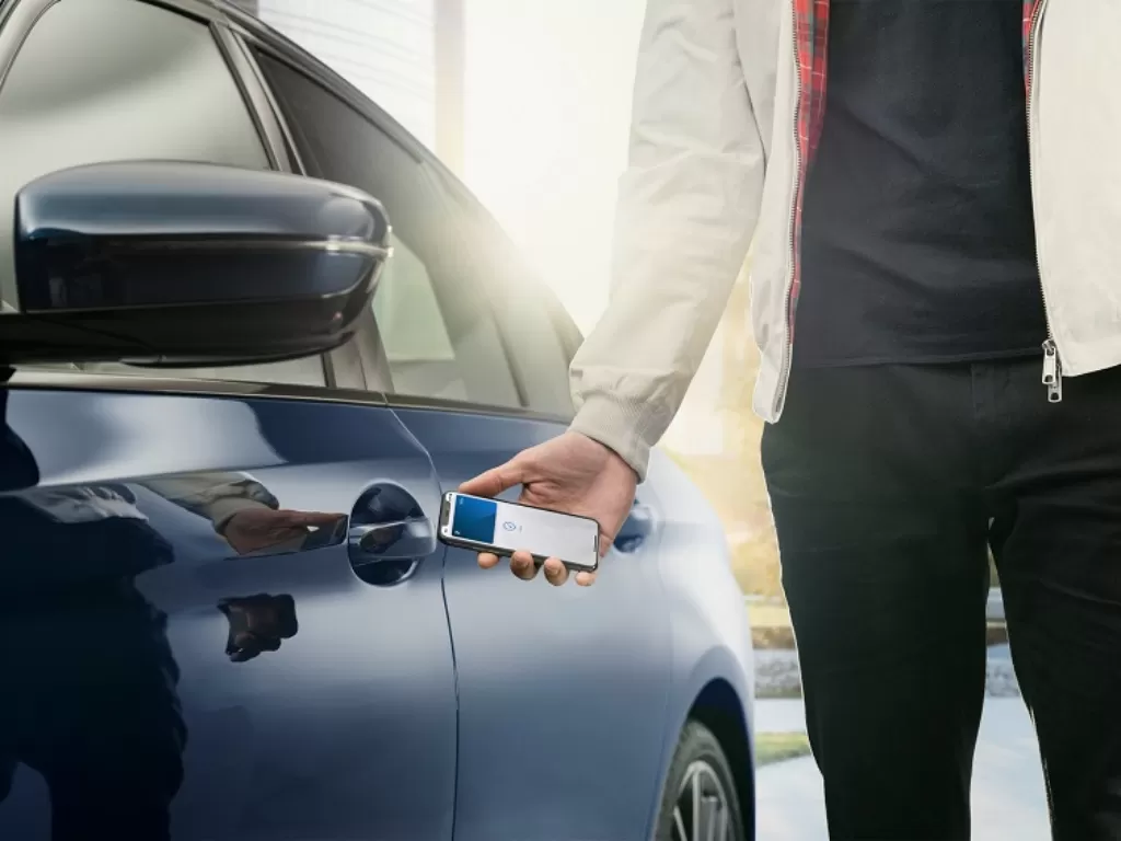 Ilustrasi pengemudi sedan BMW menggunakan kunci digital dari Apple (Dok.BMW)