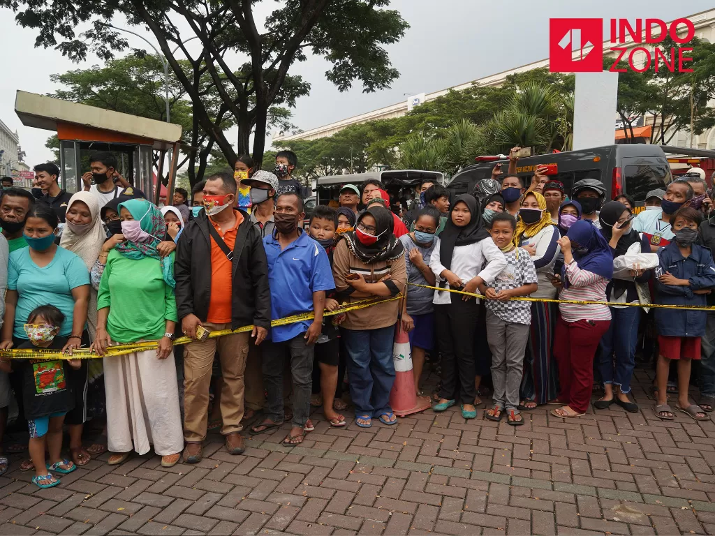 Warga berkerumun menyaksikan adegan rekonstruksi kasus penganiayaan yang dilakukan John Kei dan anak buahnya di rumah Nus Kei, Green Lake City, Tangerang, Banten, Rabu (24/6/2020). (INDOZONE/Arya Manggala)