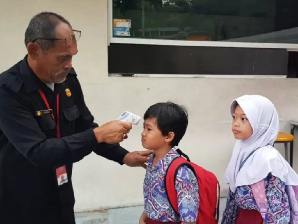 Petugas memeriksa suhu tubuh para siswa Sekolah Indonesia Kuala Lumpur (SIKL) dalam mengantisipasi penyebaran Covid-19 di Kuala Lumpur, Rabu (11/3/2020). (Photo/ANTARA/Agus Setiawan)