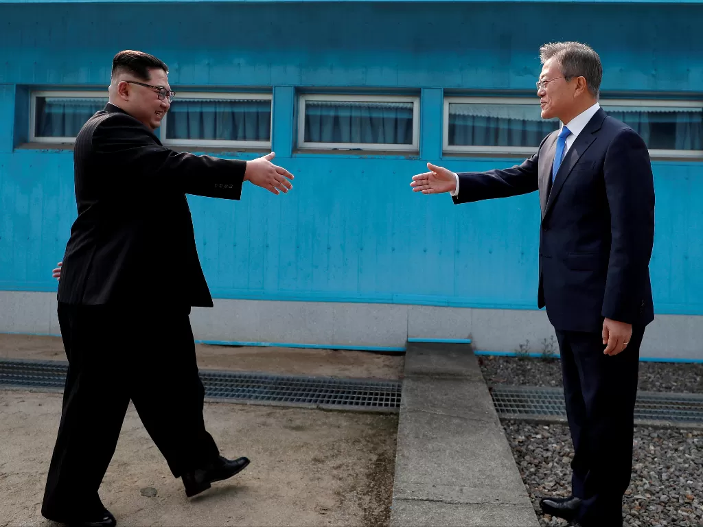 Presiden Korea Selatan Moon Jae-in dan pemimpin Korea Utara Kim Jong Un berjabat tangan di desa gencatan senjata Panmunjom. (Photo/REUTERS/Korea Summit Press)
