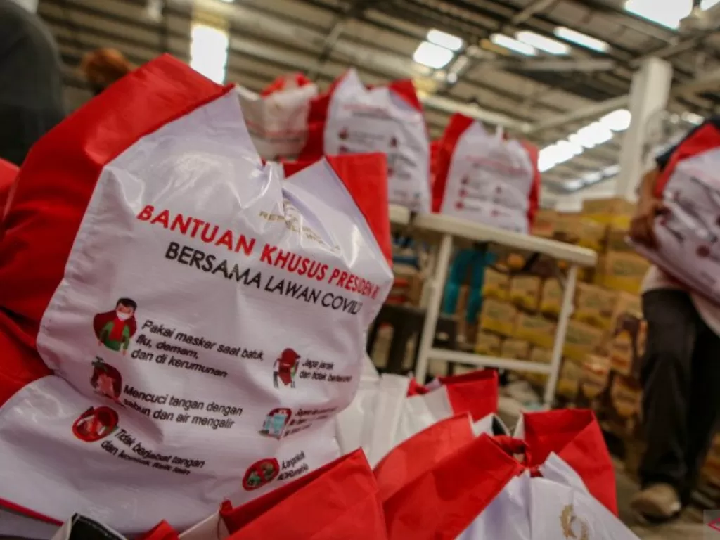 ekerja menyusun bantuan paket sembako dari Presiden Jokowi.(ANTARA FOTO/Fauzan)