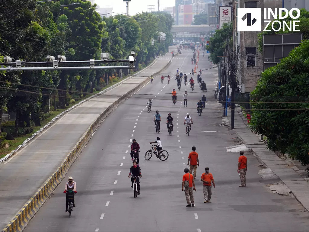 Warga berolahraga saat hari bebas kendaraan bermotor atau Car Free Day (CFD) di Jalan Gajah Mada, Jakarta, Minggu (28/6/2020). (INDOZONE/Arya Manggala)