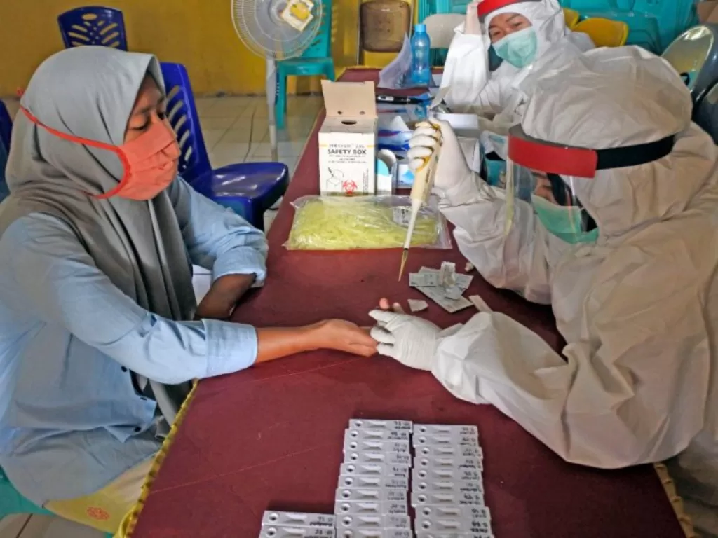 Petugas medis mengambil sambel darah warga saat tes diagnostik cepat (rapid test) COVID-19. (ANTARA FOTO/Asep Fathulrahman)