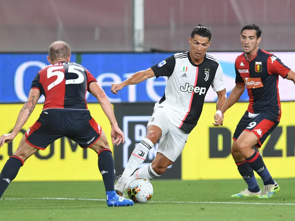 Penyerang Juventus, Cristiano Ronaldo dalam aksinya melewati dua pemain Genoa. (REUTERS/Jennifer Lorenzini)