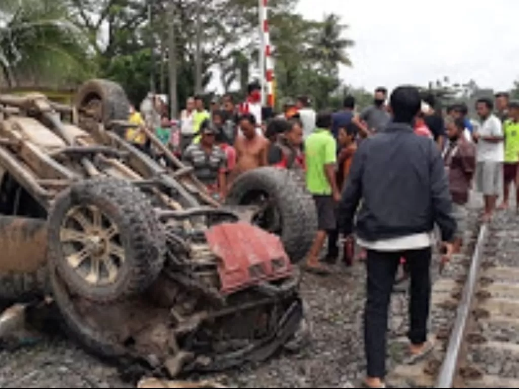 Warga melihat mobil Strada yang ditabrak kereta api di Prabumulih. (Foto: Istimewa)