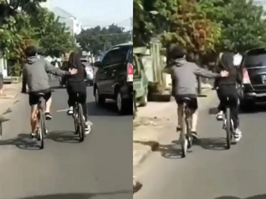 Pesepeda pria yang setia mendorong pesepeda wanita. (Photo/Twitter/@depresionistaa)