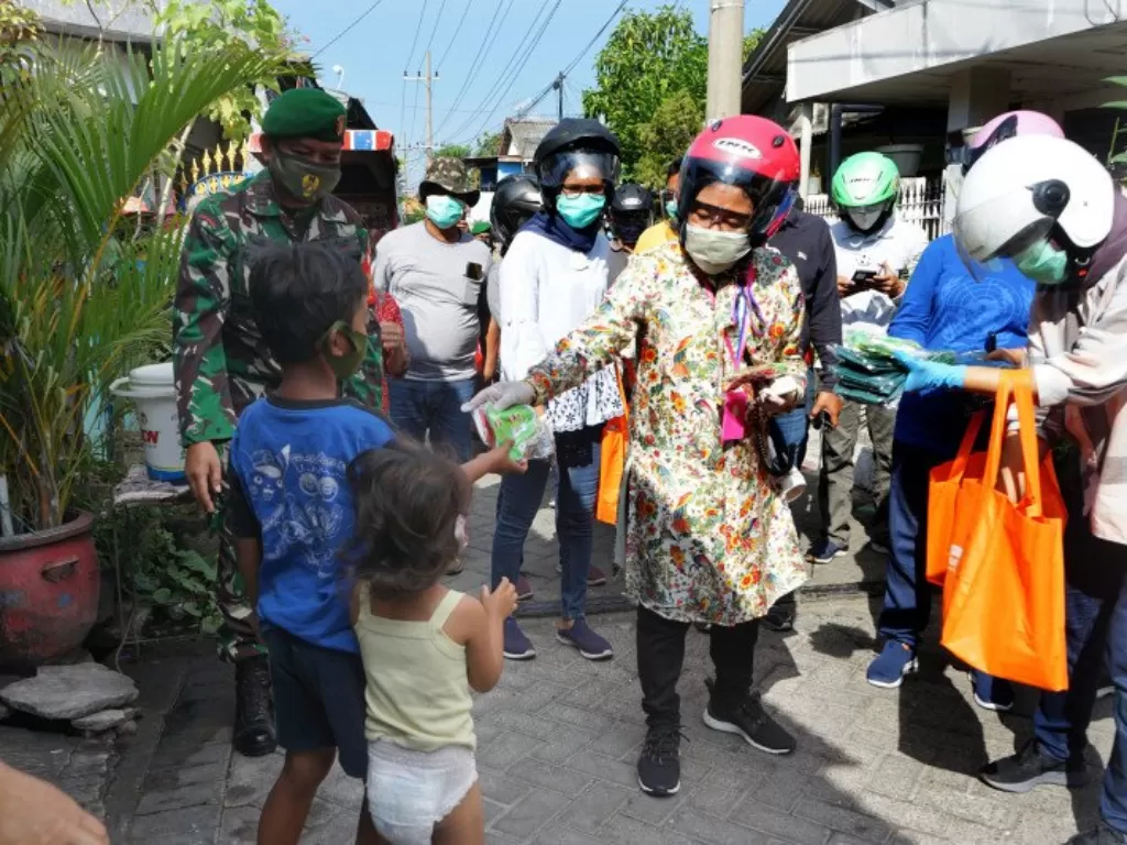 Wali Kota Surabaya Tri Rismaharini saat berkeliling kampung membagikan masker kepada warganya yang tinggal di perkampungan Kota Surabaya, Minggu (5/7). (photo/ANTARA/HO-Humas Pemkot Surabaya)