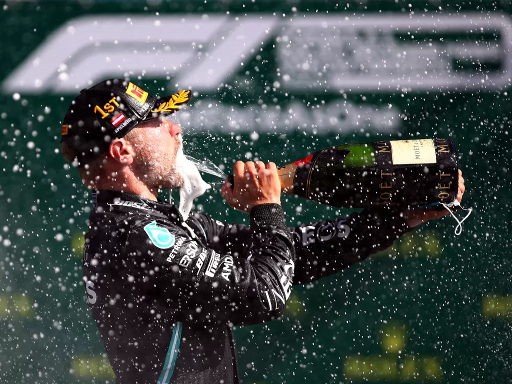 Pembalap Mercedes Valtteri Bottas merayakan dengan sampanye setelah memenangkan balapan F1 Grand Prix Austria, Spielberg, Styria, Austria, 5 Juli 2020. (Mark Thompson/Pool via REUTERS)