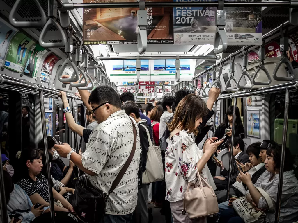 Ilustrasi orang sedang menggunakan smartphone di kereta (Ilustrasi/Unsplash/Hugh Han)