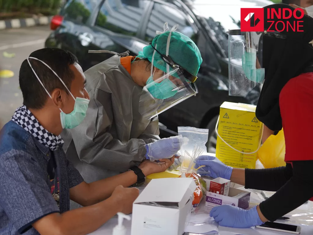 Petugas medis mengambil sampel darah jurnalis saat Rapid Test Covid-19 secara Drive-Thru di Halaman Gedung Kementerian Komunikasi dan Informatika, Jakarta, Rabu (8/4/2020). (INDOZONE/Febio Hernanto)