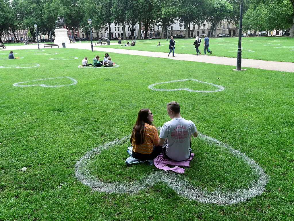 Tanda jaga jarak berbentuk hati yang dilukis oleh tim seniman dari Upfest terlihat di rumput di Queen Square, Bristol, Inggris 8 Juli 2020. (REUTERS/Rebecca Naden)