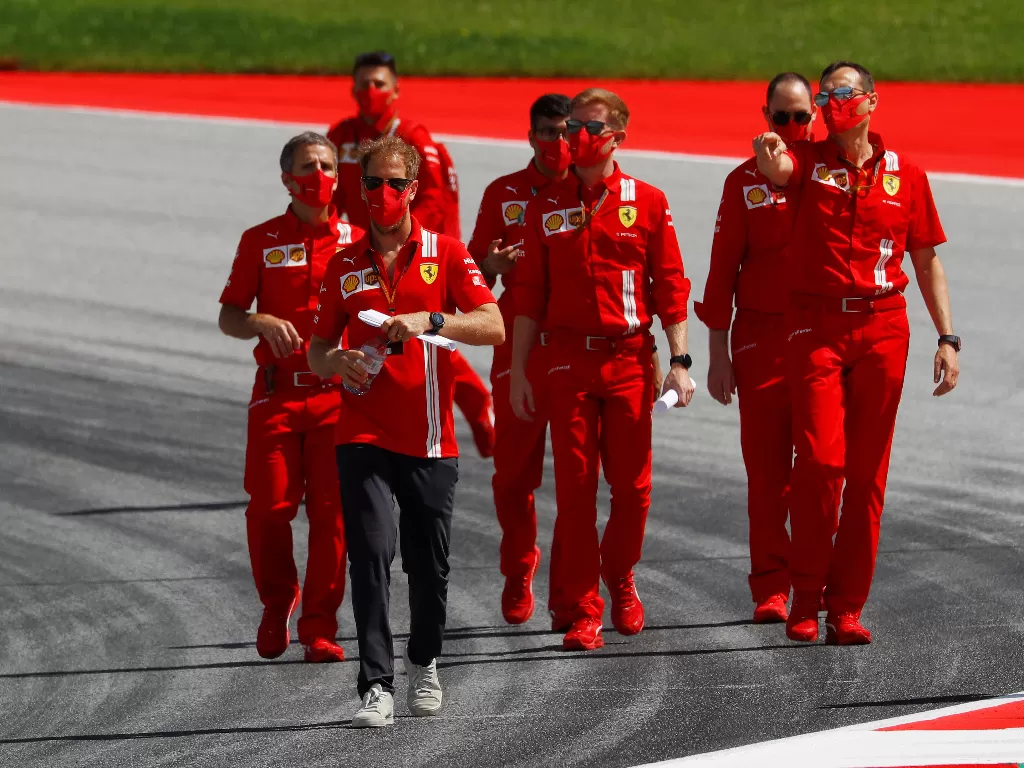Sebastian Vettel dengan anggota tim Ferrari. (REUTERS/Leonhard Foeger)