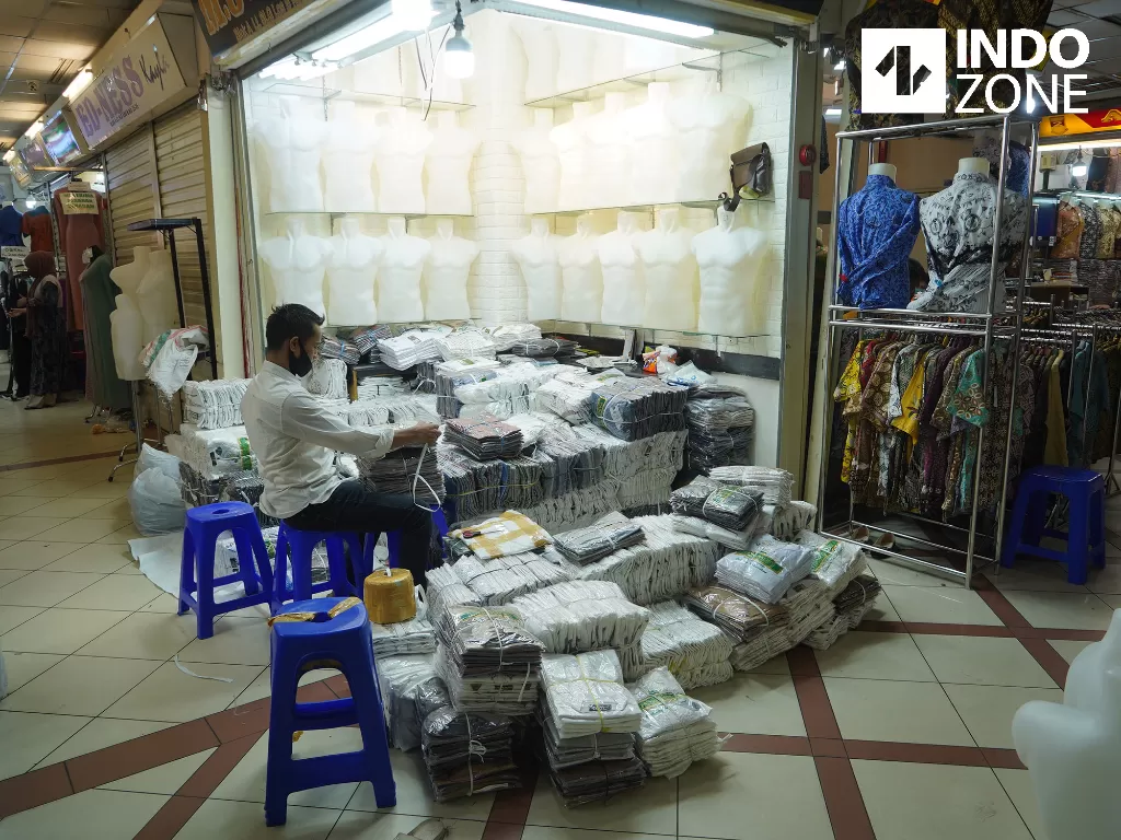 Pedagang memakai masker dan face shield saat merapikan dagangannya di Pasar Tanah Abang Blok A, Jakarta, Senin (15/6/2020). (INDOZONE/Arya Manggala) 