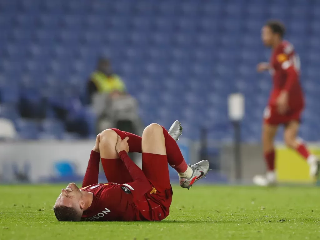 Kapten Liverpool, Jordan Henderson terbaring di lapangan akibat cedera. (REUTERS / Paul Childs)