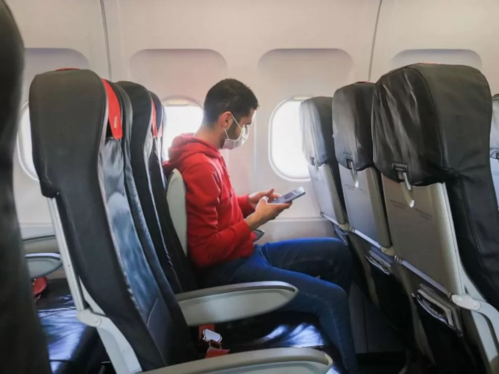 Ilustrasi penumpang pesawat memakai masker. (abcnews.com)