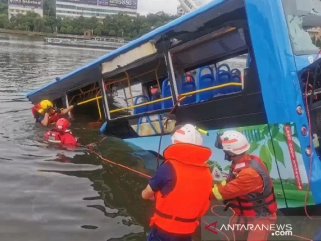 Petugas tengah melakukan evakuasi terhadap bus yang sengaja diceburkan ke danau. (ANTARA/HO-CCTV)