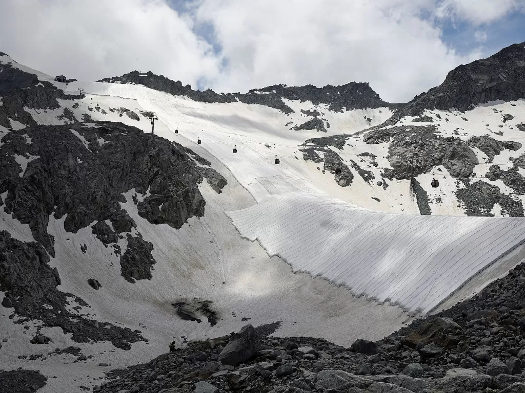 Sebuah terpal putih besar terlihat menutupi gletser Presena Italia utara untuk menunda pencairan salju di lereng ski dan memantulkan sinar matahari selama musim panas, di Italia, 13 Juli 2020. (REUTERS/Flavio Lo Scalzo)