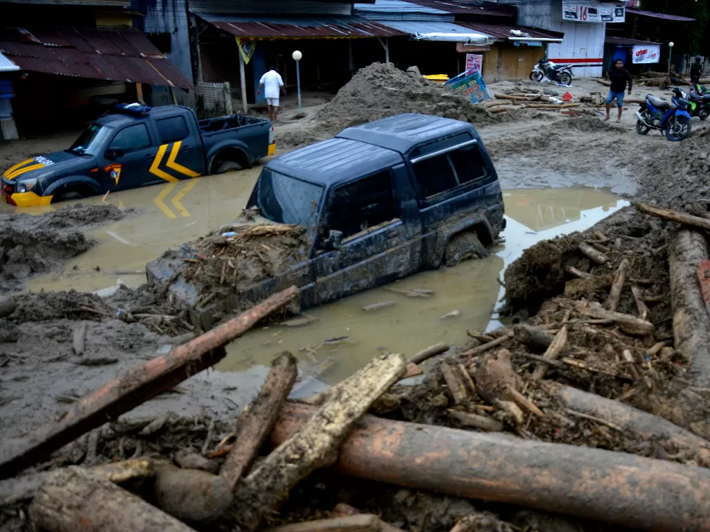 Kondisi rumah dan mobil yang tertimbun lumpur akibat terjangan banjir bandang di Kecamatan Masammba, Kabupaten Luwu Utara, Sulawesi Selatan, Rabu (15/7/2020). (ANTARA FOTO/Abriawan Abhe)