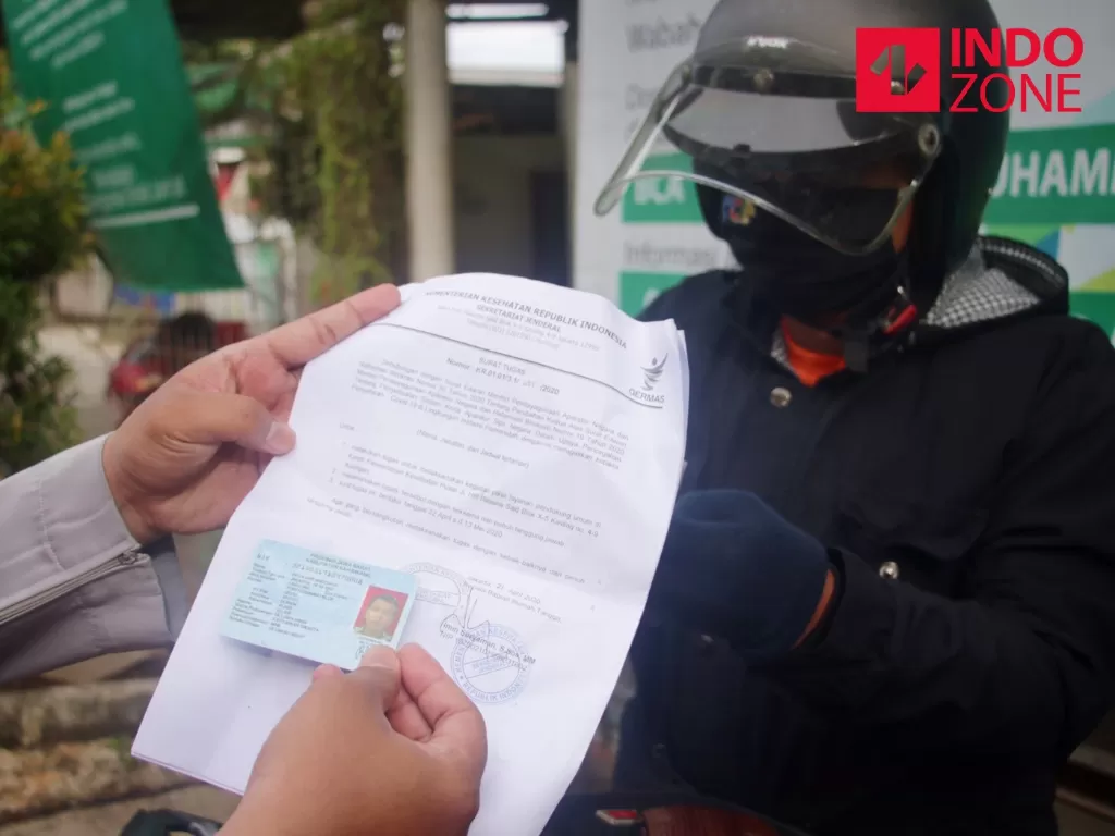 Petugas memeriksa kelengkapan Surat Izin Keluar Masuk (SIKM) Jakarta di Cek Poin PSBB Lampiri, Kalimalang, Jakarta, Selasa (26/5/2020). (INDOZONE/Febio Hernanto)