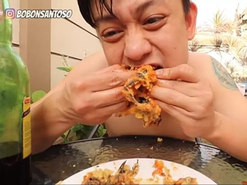 Pria menyantap kelelawar goreng tepung. (Screenshoot/YouTube/The Santoso)