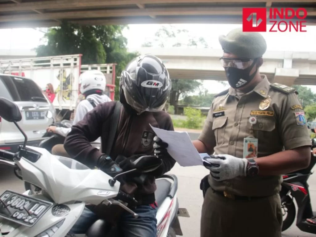 Petugas memeriksa kelengkapan Surat Izin Keluar Masuk (SIKM) Jakarta di Cek Poin PSBB Lampiri, Kalimalang, Jakarta. (INDOZONE/Febio Hernanto)